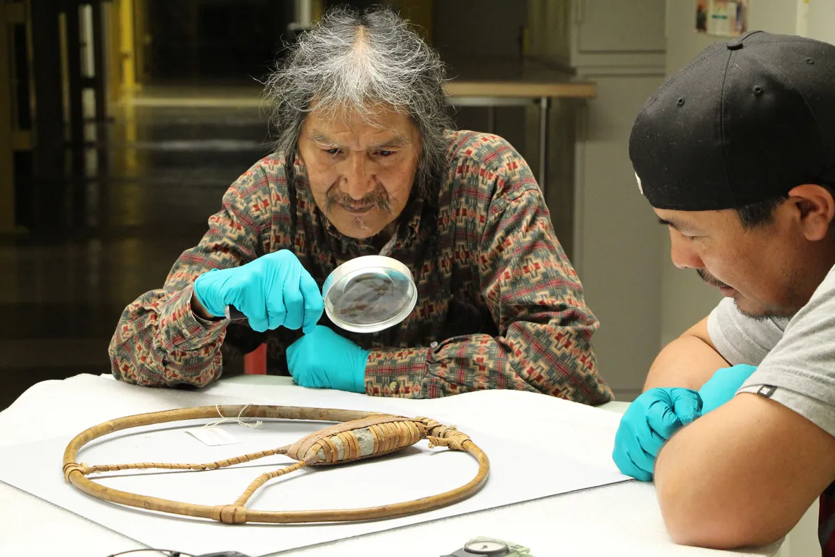 Wanapum tribe member examines object with magnifying glass