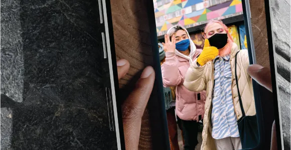 an image of a cellphone taking a picture of a cellphone photo of two women wearing masks