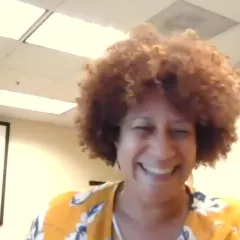 Video still of a medium-light-skinned woman smiling
