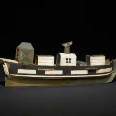 Painted wooden model of a steam ship with several structures on its deck.