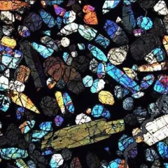 Brilliant mix of shapes colors like stained glass of a thin section of Antarctic meteorite.