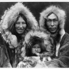 Two adults and young child in fur-lined parkas