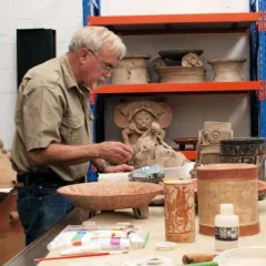 Ronald Bishop examining archeological artifacts