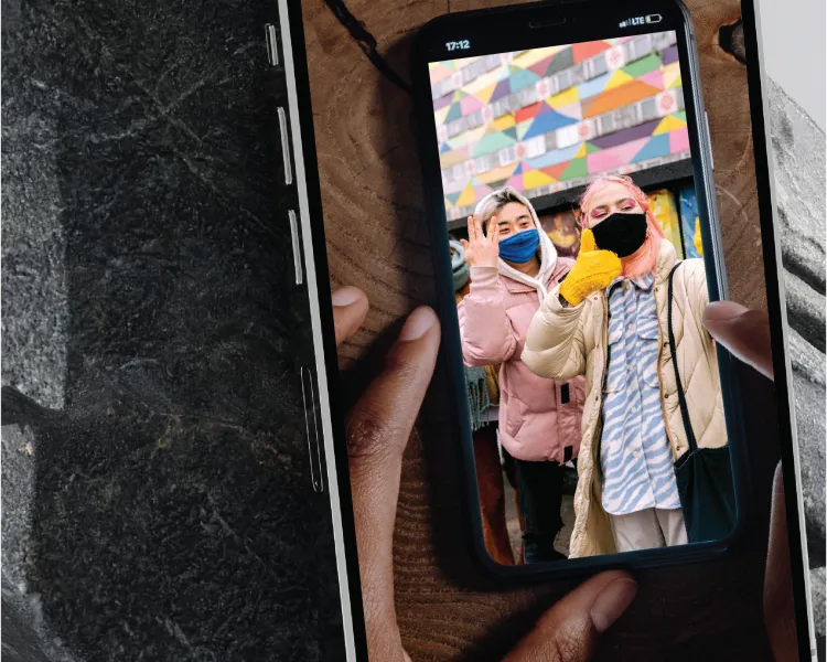 an image of a cellphone taking a picture of a cellphone photo of two women wearing masks
