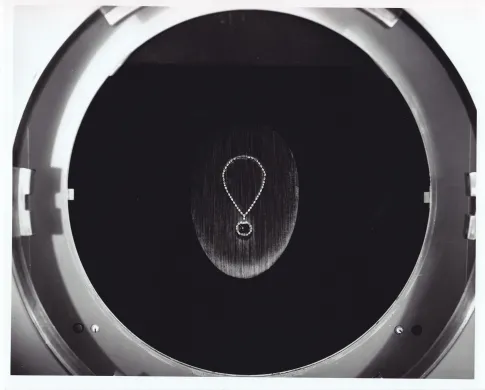 The Hope Diamond necklace in a dark, circular viewing case