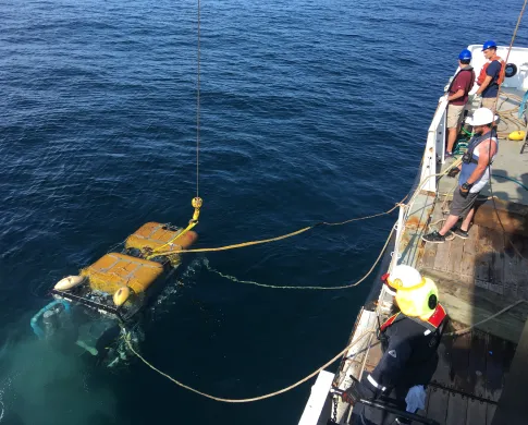 A Remote Operated Vehicle being deployed off the side of a ship
