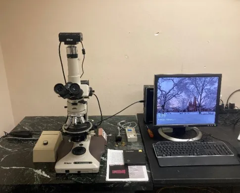 Off-white petrographic scope with camera next to a computer