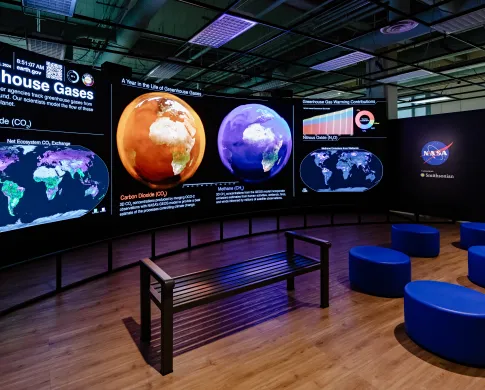 exhibit hall with screens showing an orange and blue satalite image