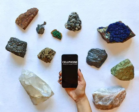 a hand holding cellphone infant of an array of minerals
