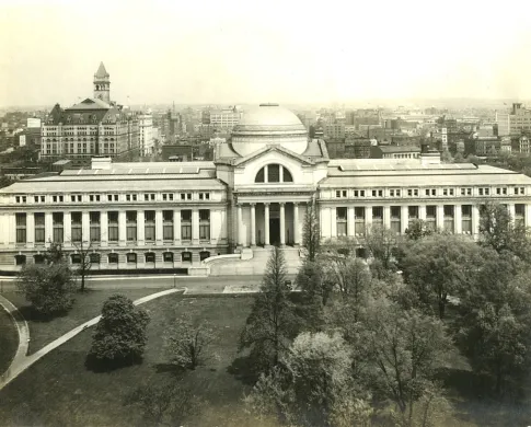 A large building featuring a dome and two wings