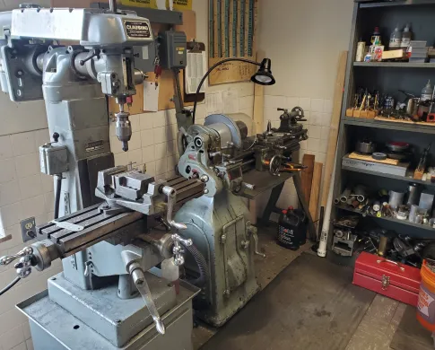 Mill and lathe next to a metal shelving with bits and other parts