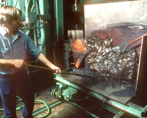 Man using a wire saw to cut an iron meteorite
