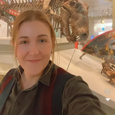woman with blond hair in front of fossil exhibit