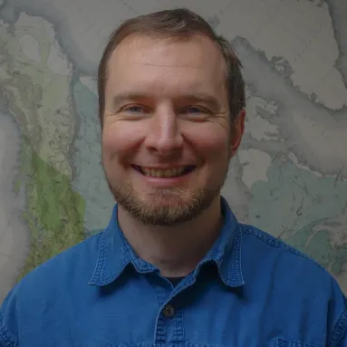 adam behlke in front of a map