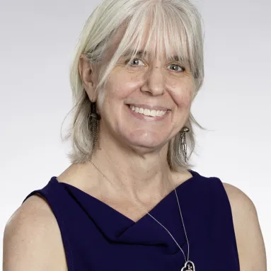 A smiling woman against a white background posing for a photo