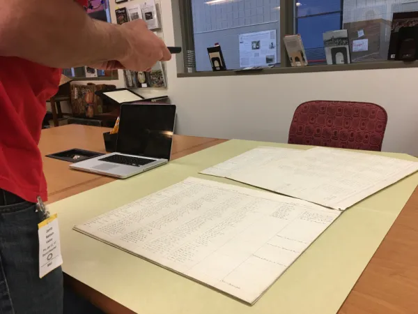 Person taking a picture of archival documents.