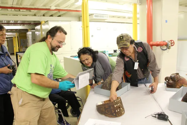 People looking at and videoing a Tlingit visor.