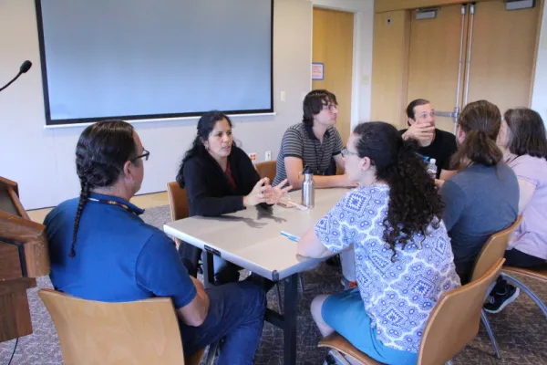 Group of people sitting at a conference table and talking.