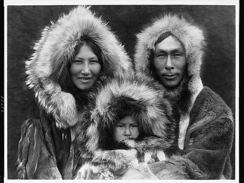 Two adults and young child in fur-lined parkas