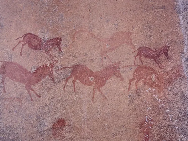 A prehistoric, reddish-brown painting of animals on a rock shelter in Mashonaland, Zimbabwe