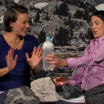 Host Maggy Benson and geologist Elizabeth Cottrell laugh after being sprayed with seltzer water on the set of a webcast.