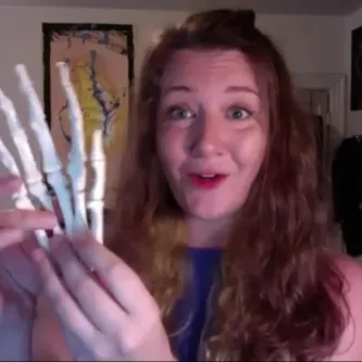 Andrea Eller holding a plastic skeletal model of a human hand