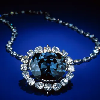 A blue diamond necklace on a blue background