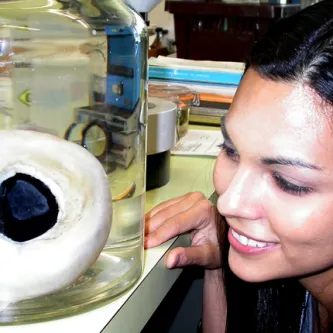 Woman looking at jar with giant squid eye inside