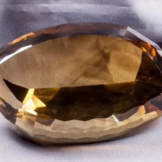 Large brown and yellow, faceted gem in the shape of an American football.