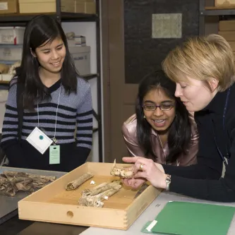 Smithsonian forensic anthropologist points out area of interest in a piece of bone to students.