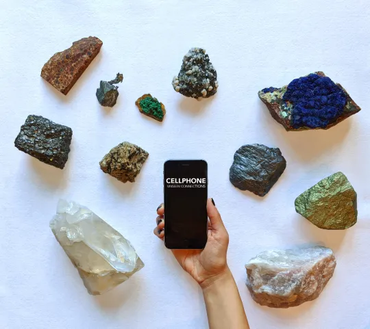a hand holding cellphone infant of an array of minerals
