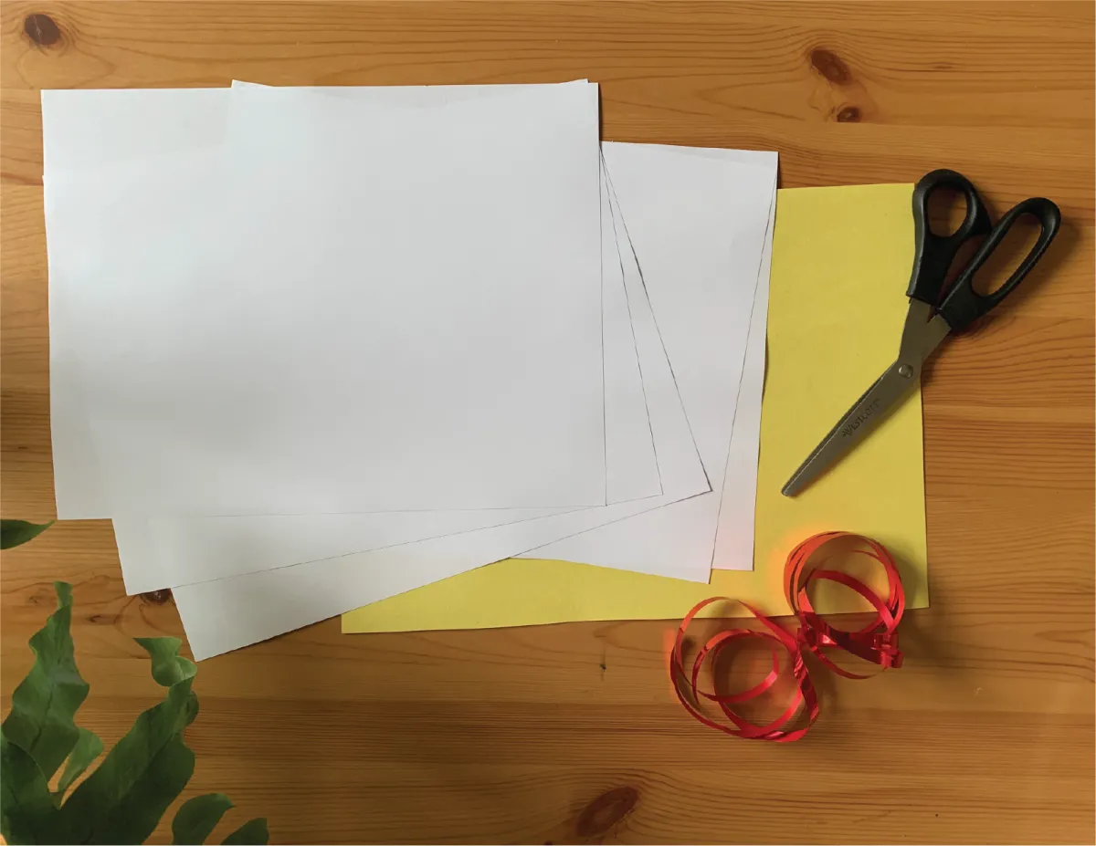 Sheets of paper, scissors, and thread on a table