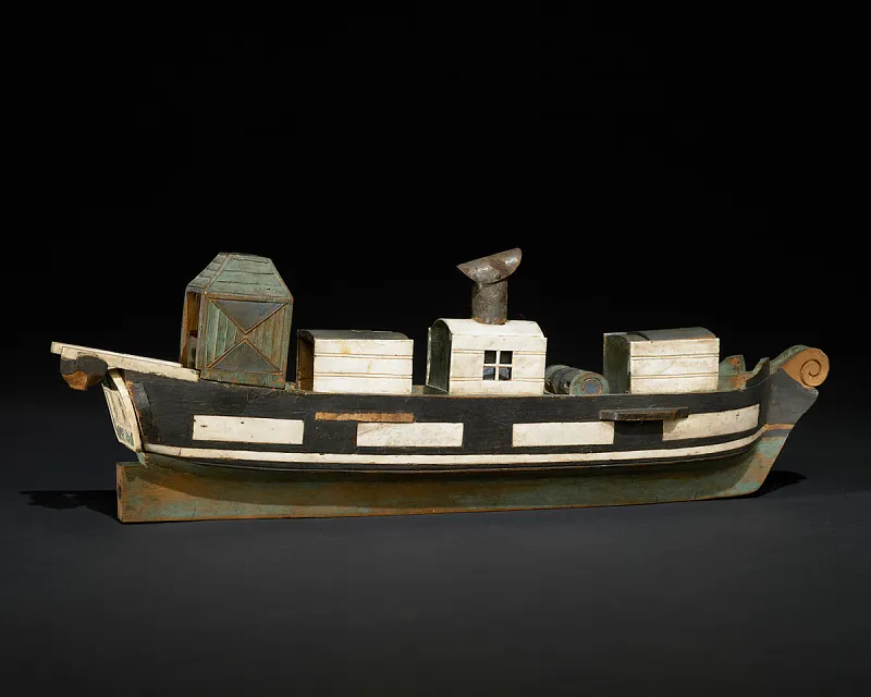 Painted wooden model of a steam ship with several structures on its deck.