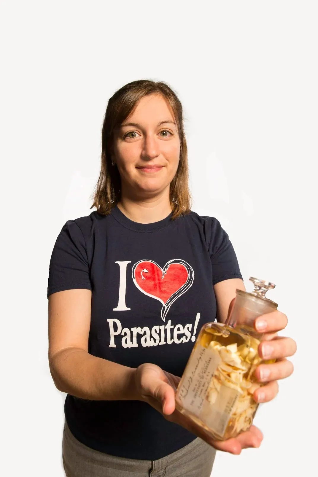 A woman holding a jar with a leech inside of it