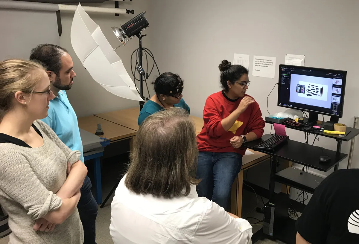 Group of people looking at images of artifacts on a screen