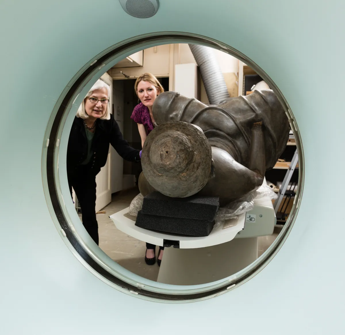 Two scientists putting sculpture into CT scanner