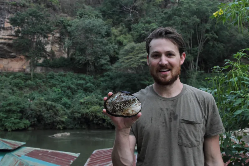 John Pfeiffer holding up a mussel