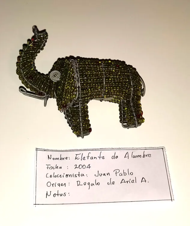 Image of a small elephant sculpture and an accompanying object label with descriptive information