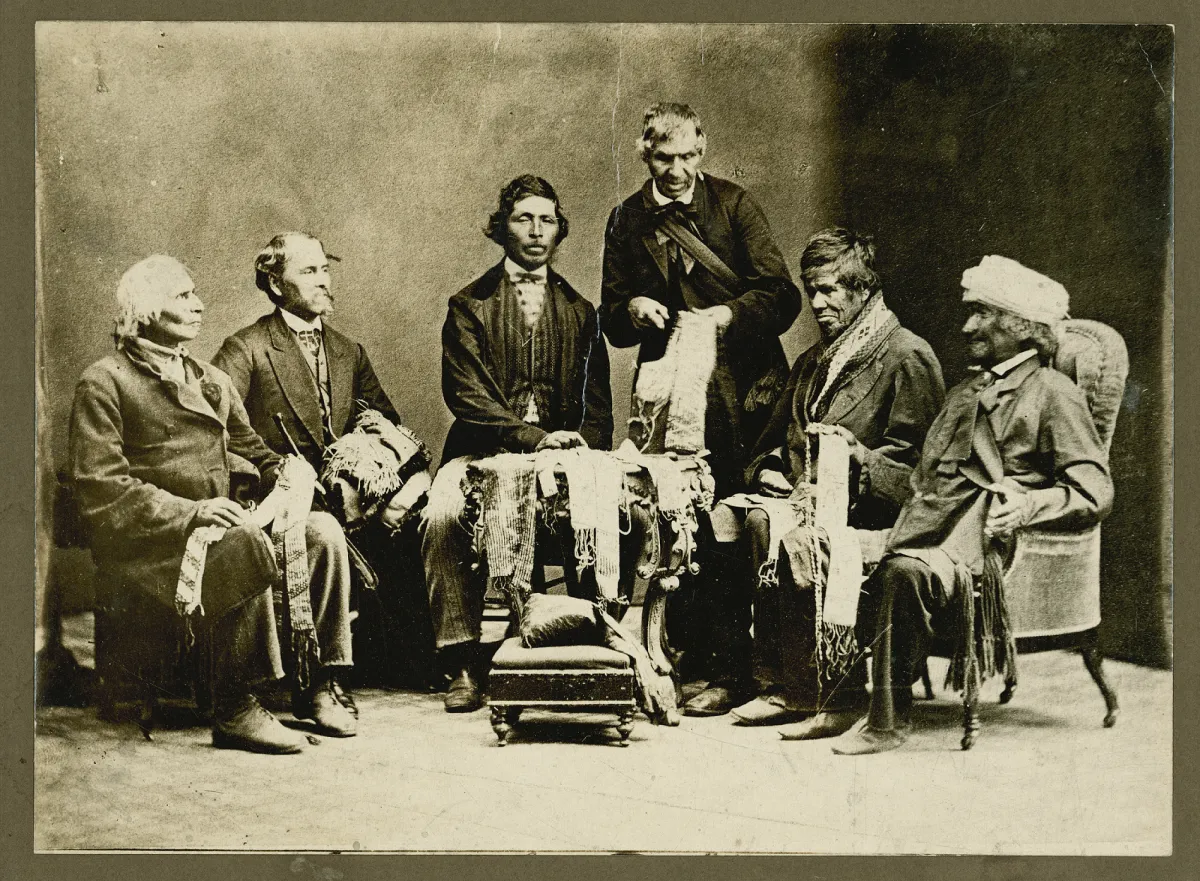 1871 photograph of the Chiefs of the Haudenosaunee, or Six Nations of the Iroquois Confederacy. The six men are sitting in a semicircle and holding wampum belts in their laps.