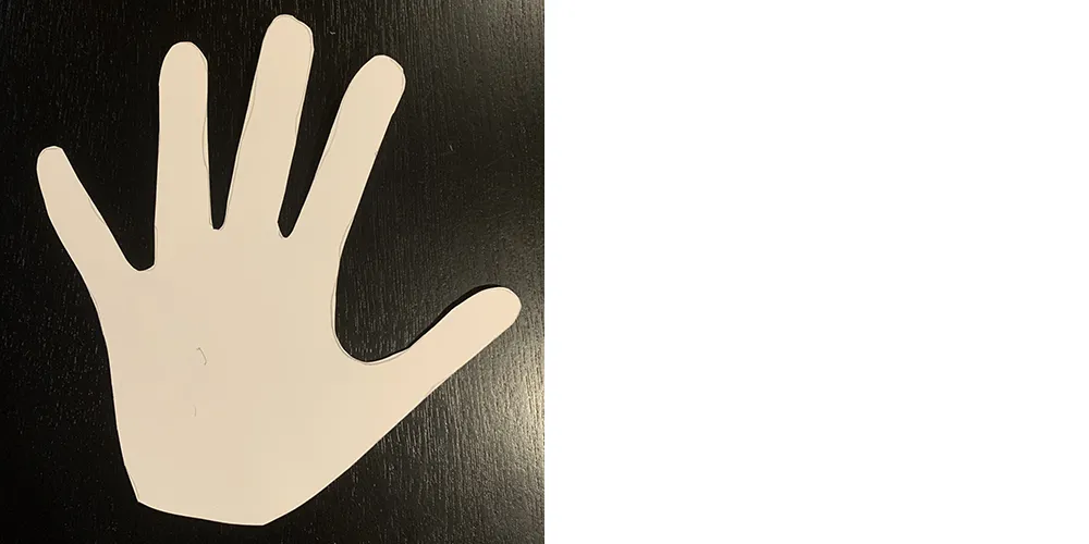 Shape of a human hand cut out from a piece of paper.