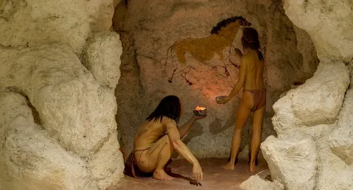 Prehistoric men painting in a cave
